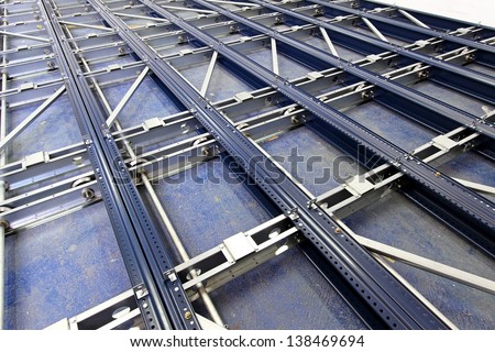 Metal base and rollers for automated shelving system