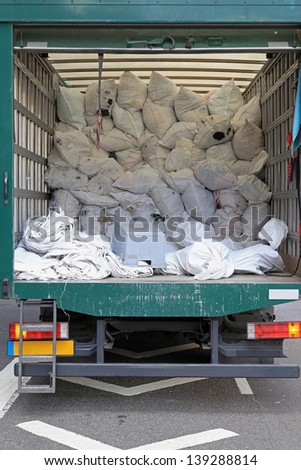 Big delivery truck collecting dirty laundry bags