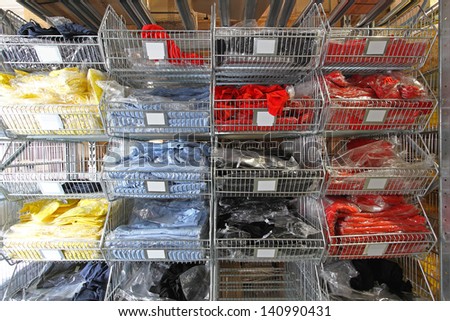 Warehouse shelf with colourful T shirts and textile goods
