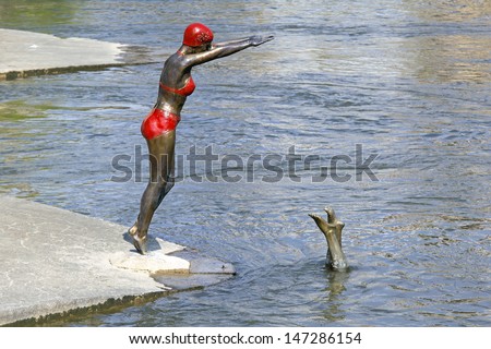 SKOPJE, MACEDONIA - SEPTEMBER 17: Swimmer statue in Skopje on Sept 17, 2012. Bronze statue of swimmer woman in bikini at Vardar River in Skopje, Macedonia.
