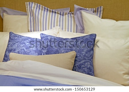 Cotton bed sheets with big pile of pillows