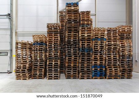 Stack of used wooden pallets in distribution center