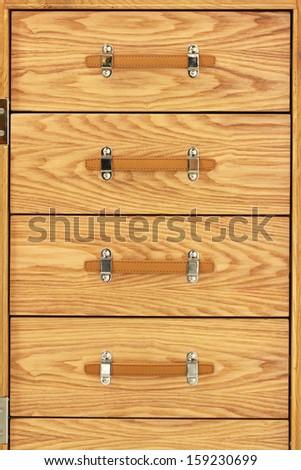 Wooden chest of drawers with leather handles closed