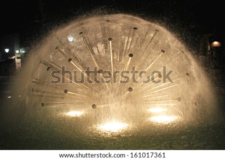 Modern fountain spraying water at night
