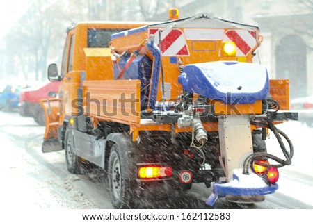 Spreader truck in winter snow blizzard weather