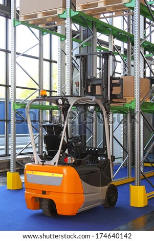Small electric forklift truck in distribution warehouse