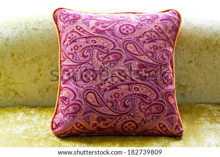 Purple pillow at green sofa