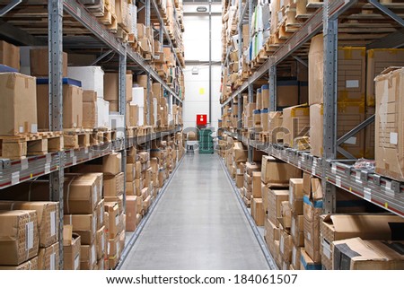 Warehouse rows with cardboard boxes and goods at shelves