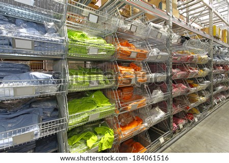 Warehouse shelf with colourful shirts and textile goods