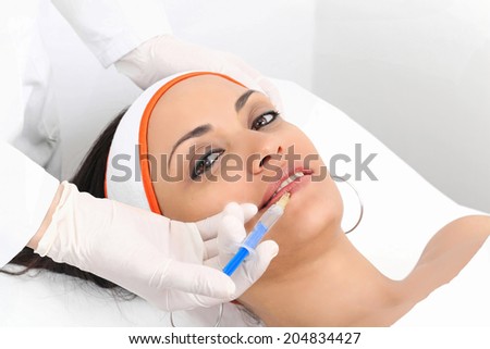 Young woman having lip augmentation at beauty clinic