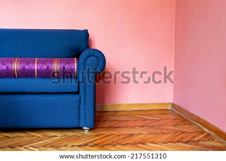 Part of blue sofa and pink corner