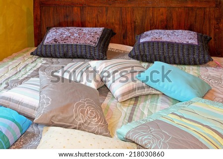 Bunch of pillows and blankets over double bed