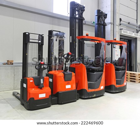 Four red forklift trucks in distribution warehouse Four red forklift trucks in distribution warehouse
