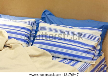 Two blue pillows with straps on double bed