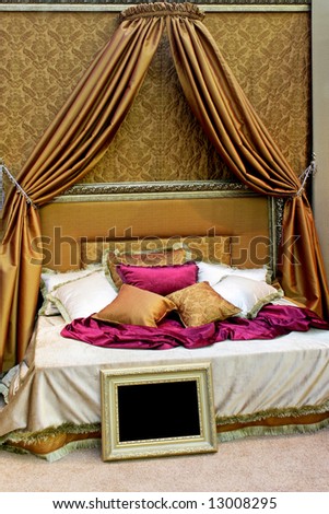 Bed with golden canopy in big bedroom