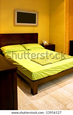 Bedroom with green double bed and picture frame