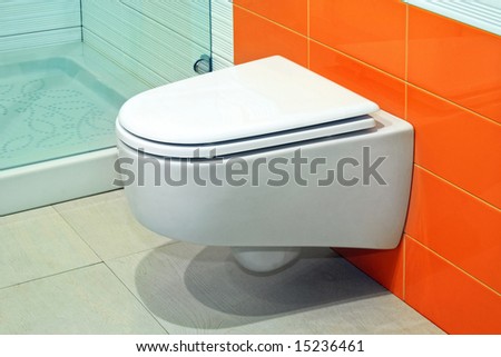 Modern shape ceramics toilet over orange tiles