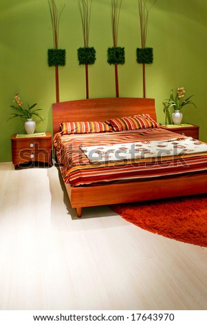 Green bedroom with wooden bed and flowers vertical