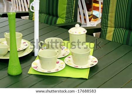 Picnic table with mugs and plates all in green