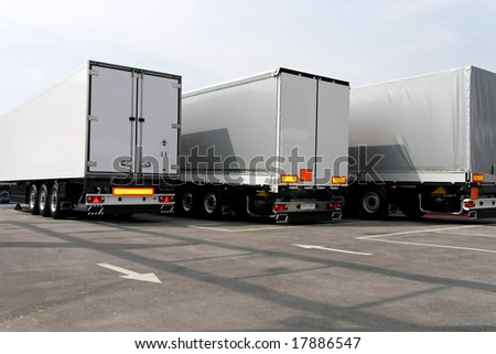 Three big lorry trailers in grey color