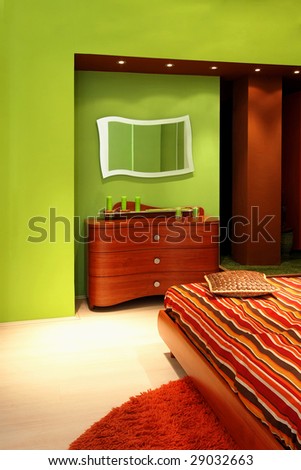Interior of green bedroom with mirror and drawers