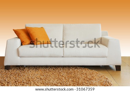 White leather sofa with two orange pillows
