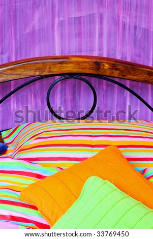Colorful sheets and pillows in purple room