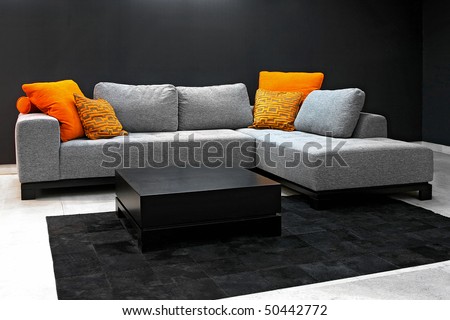Grey sofa in living room with dark walls