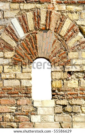 Very old brick wall with arch window