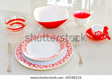Love tableware with red hearts at glass table