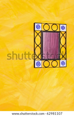 Old ironwork frame mirror at yellow wall