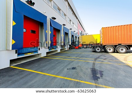 Forklift and trucks at cargo dock of warehouse
