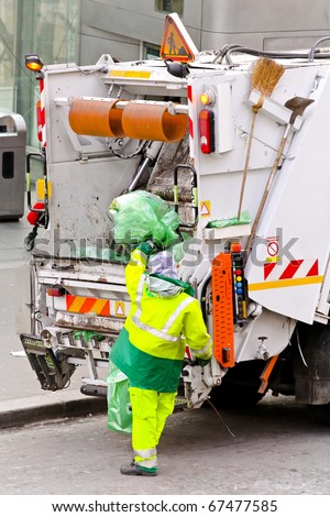 Garbage worker with bag at dump truck