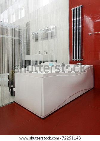 Modern bathroom interior with hydro massage bathtub and red ceramic tiles