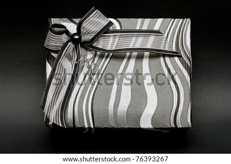 Modern silver gift box with bow at black