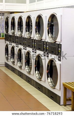 A row of industrial washing machines in laundry shop