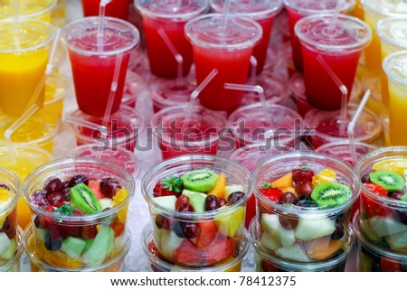 Big pile of freshly made fruit salads and squeezed juices