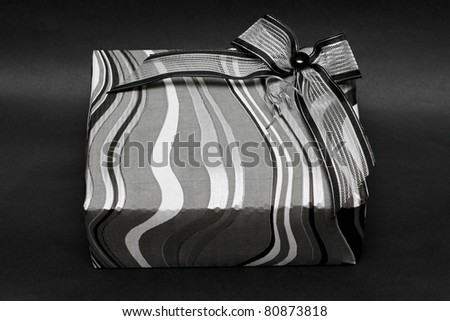 Modern silver gift box with bow at black