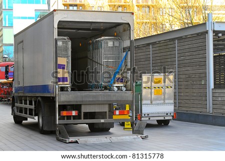Open back door of delivery truck parked outside store