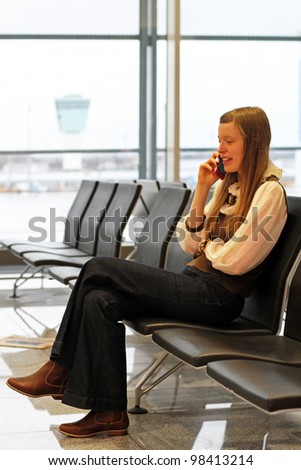 Girl at an airport making a call while waiting for her flight