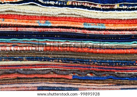 Big pile of colorful carpets and rugs