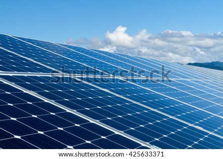 Solar panel against clouds and blue sky.