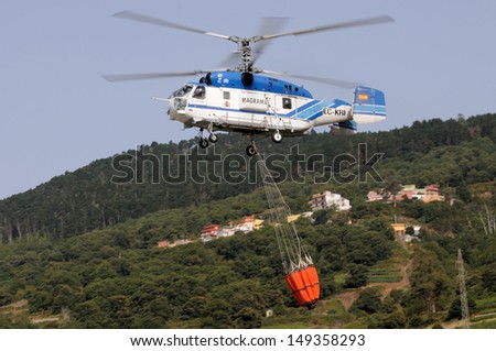 SANTA CRUZ DE TENERIFE, AUGUST 3: Fire fighting Helicopter Kamov KA-32a-11BC, with bambi basket, during a fire fighting in the bush. August 3, 2013, Tenerife (Canary Islands) Spain.