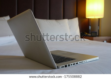 silver laptop on a bed in hotel room