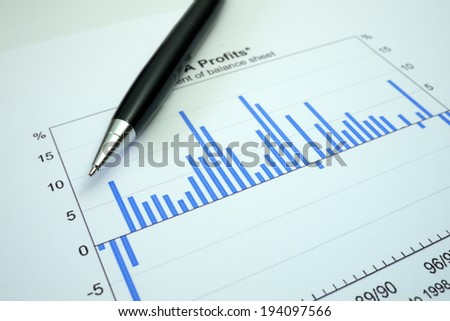 pen lying on a document of share results