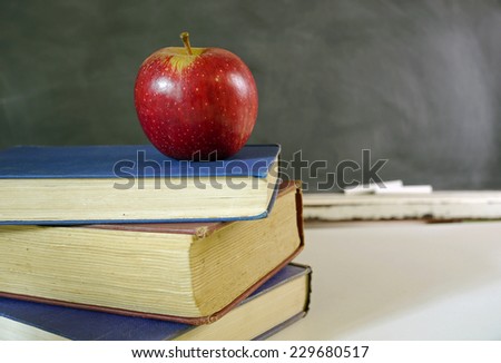 Red apple on books in classroom