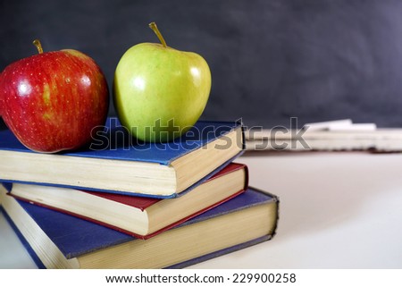 two apples on books in classroom
