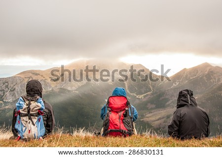Hikers resting in beautiful mountains with outdoor gear.