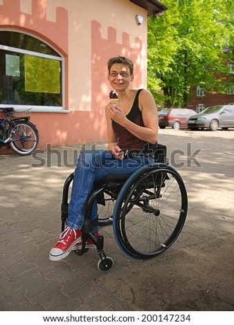 Disabled woman smiling and eaten ice cream, urban scene