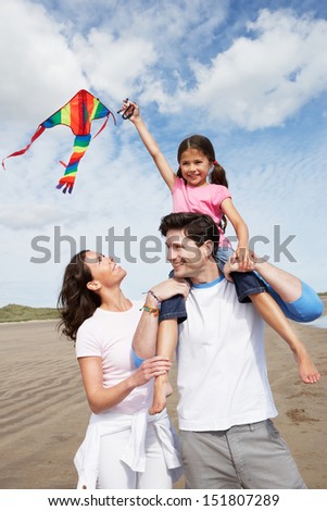 Family Having Fun Flying Kite On Beach Holiday